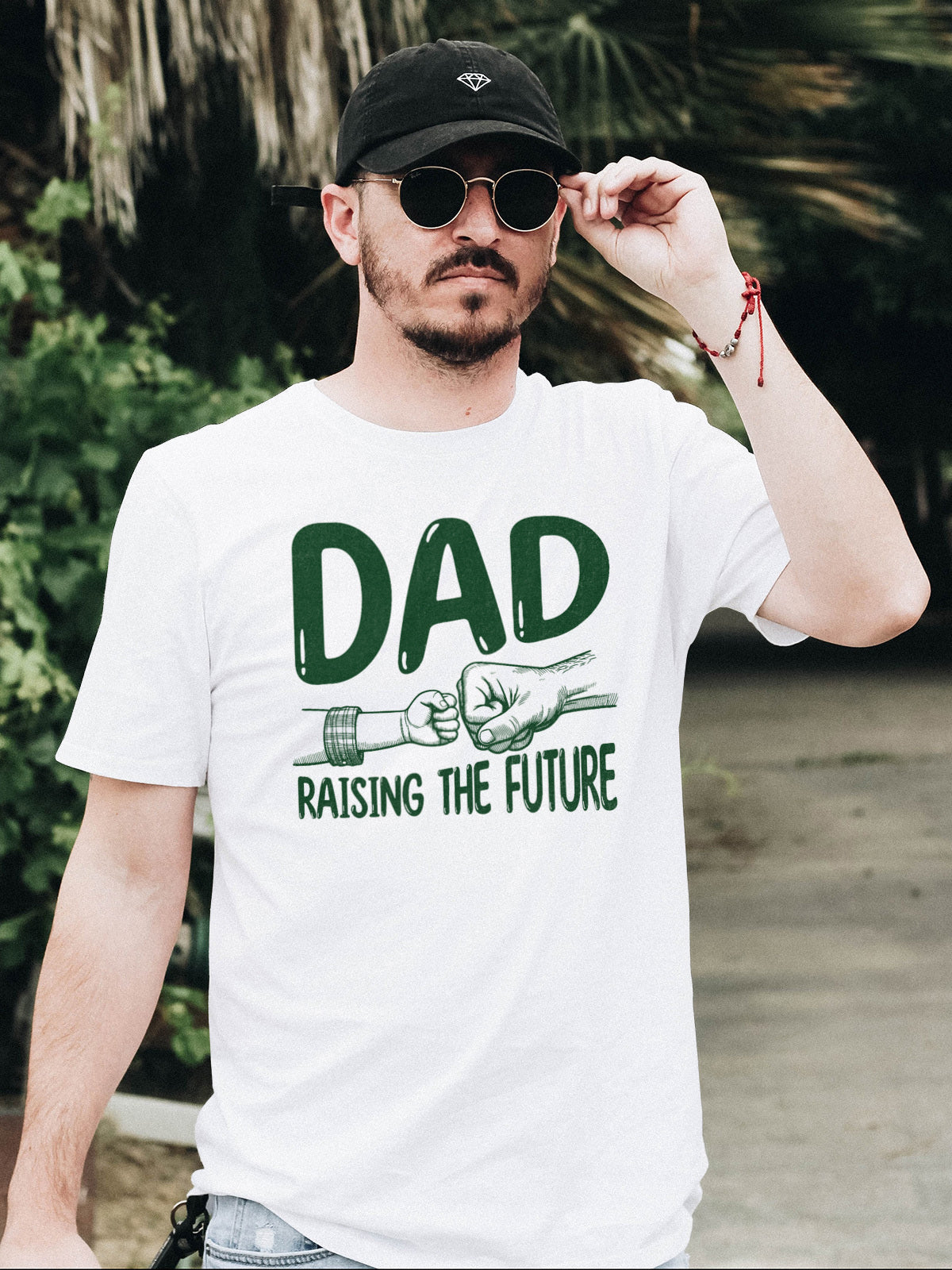 Father's day t-shirt that says Dad Raising the Future in green font with image of dad and child fist bump