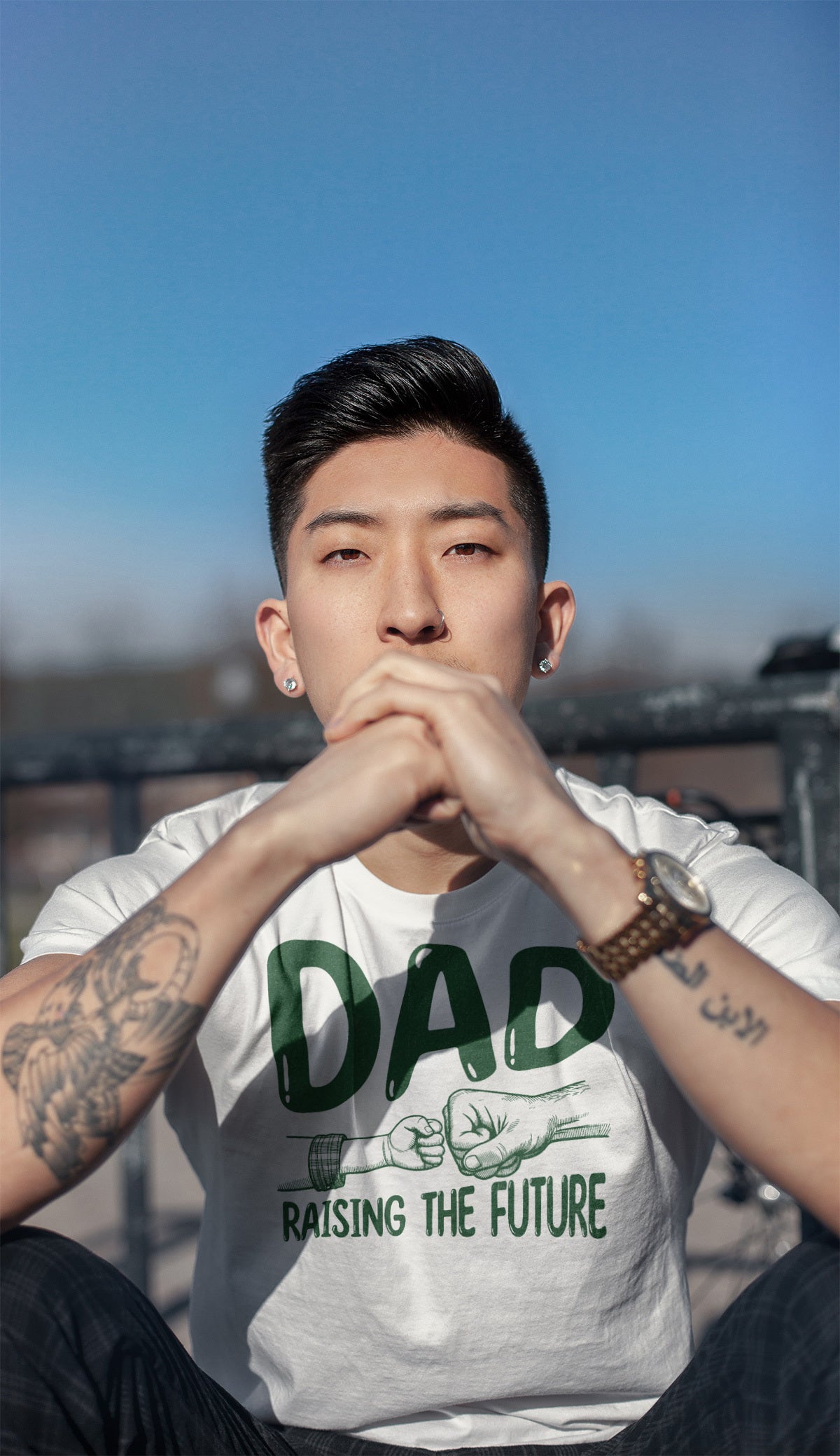 Father's day t-shirt that says Dad Raising the Future in green font with image of dad and child fist bump displayed on white shirt. Various shirt colors available.